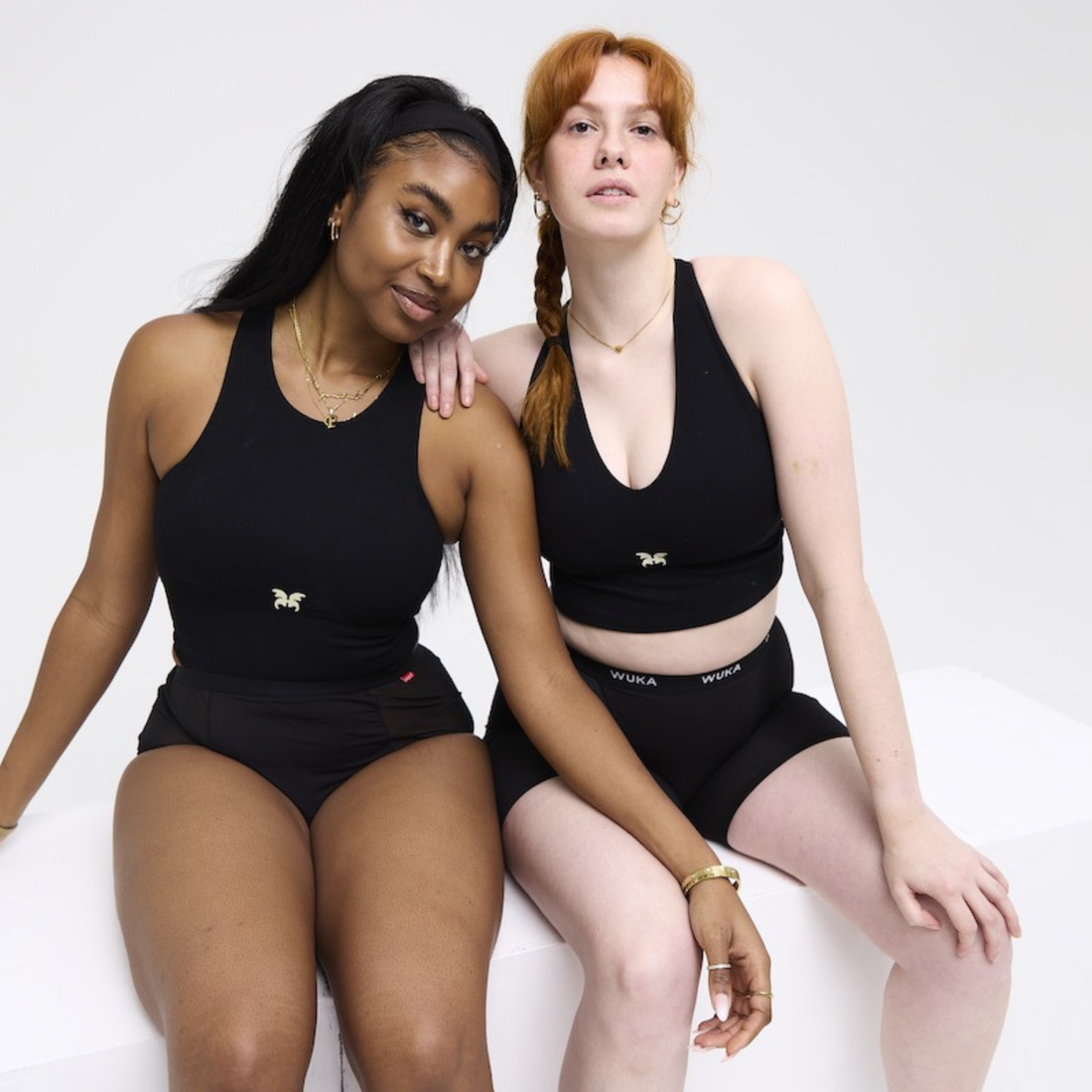 two girls wearing the WUKA boxers and stretch and smiling at the camera